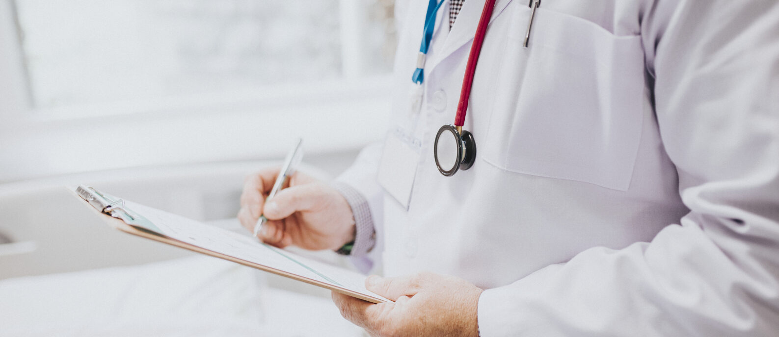 Physician noting down symptoms of a patient